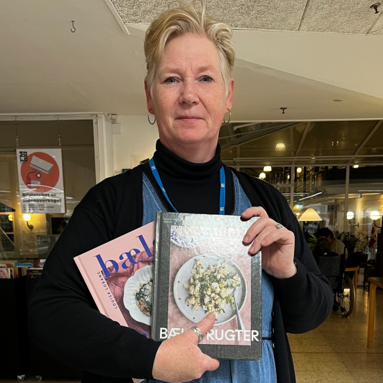 Foto af bibliotekar med kogebøger i favnen