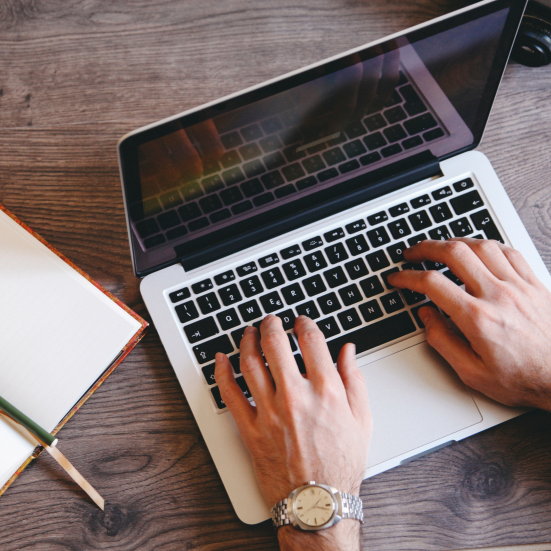 Hænder der skriver på en laptop.