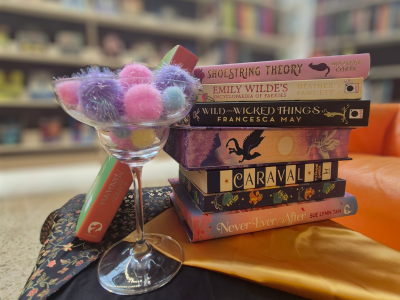 Foto af et lille tableau af romantasy-bøger og en mocktail på Faaborg Bibliotek.