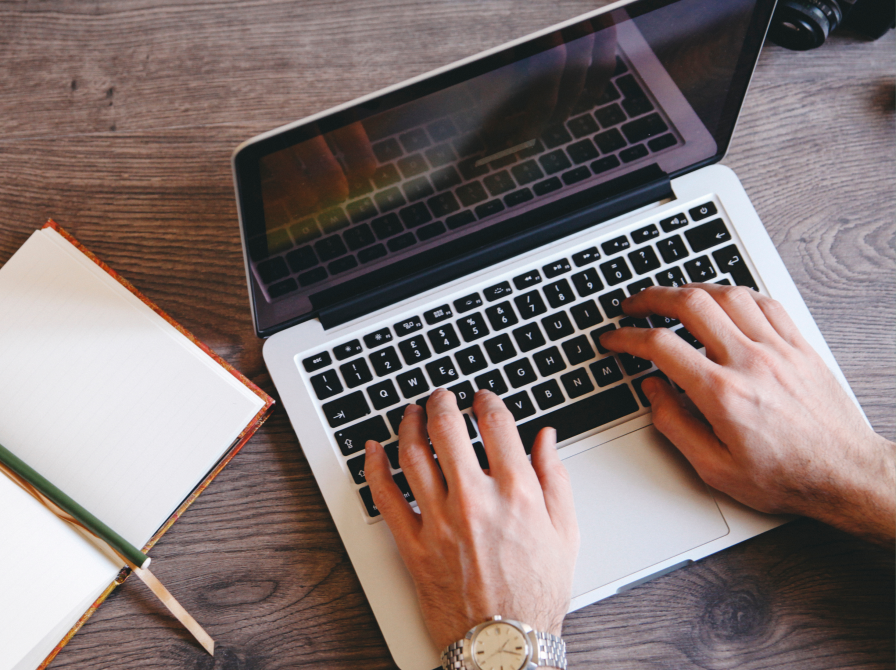 Hænder der skriver på en laptop.