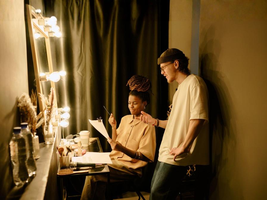 To personer i teatergarderobe kigger i manus