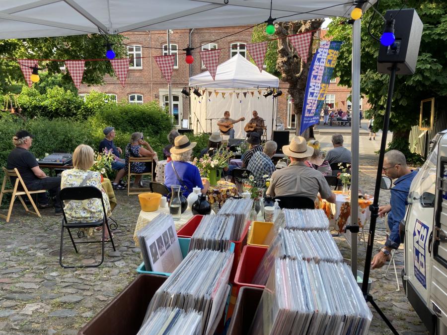 Duo spiller på scene for publikum med en vinylcafe i forgrunden